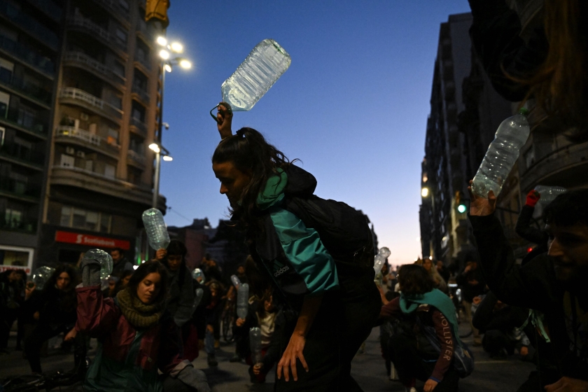 People waving empty water jugs at a protest.