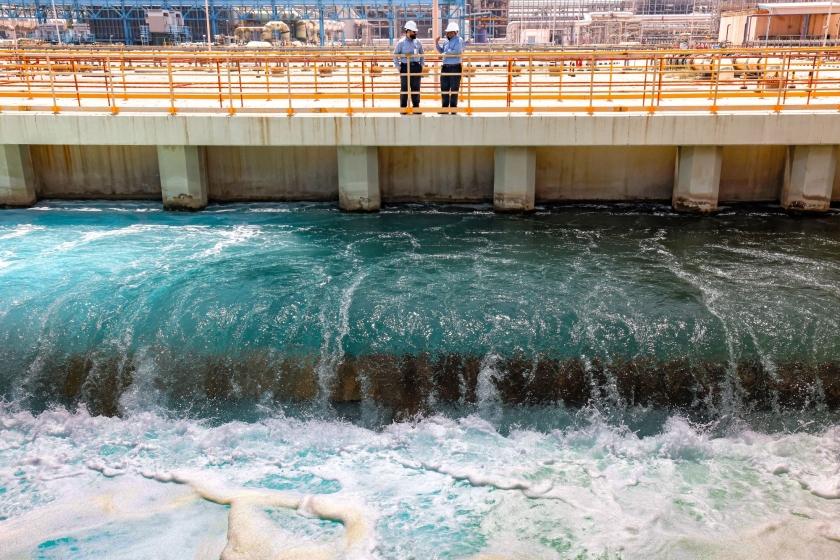 Two men standing over flowing water