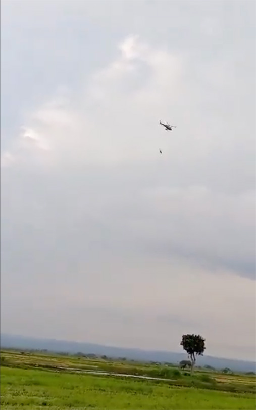 TANAPA helicopter taking away farming equipment from farmers living outside of RUNAPA TANAPA helicopter taking away farming equipment from farmers living outside of RUNAPA