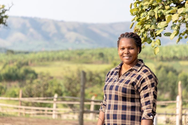 A woman standing in a field, smiling